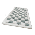 Checkered quilt with white and gray squares on a white background